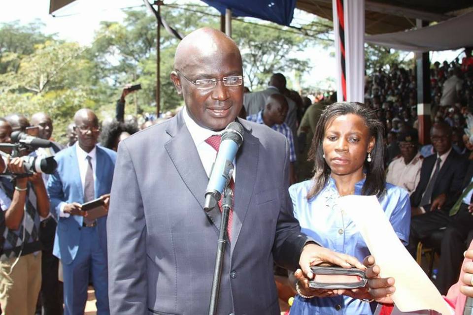 Bungoma Governor Wycliffe Wafula Wangamati places hand on bible during his swearing in ceremony at Kanduyi stadium