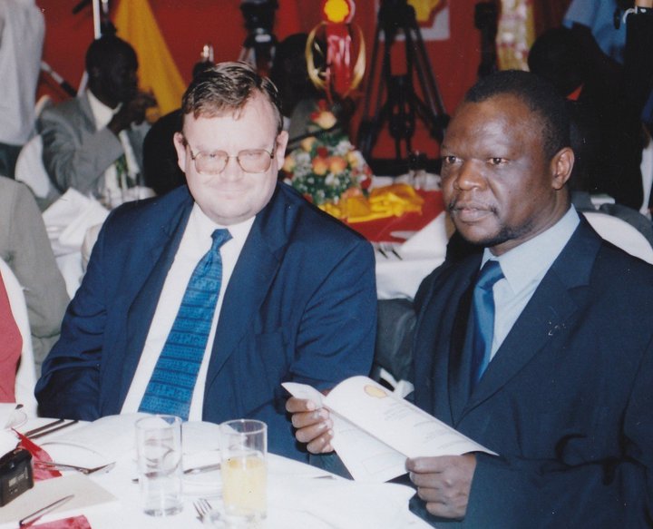 Mr Christopher Situma Khaemba, a legendary Western high school principal, with an unidentified Caucasian male at a dinner event.   