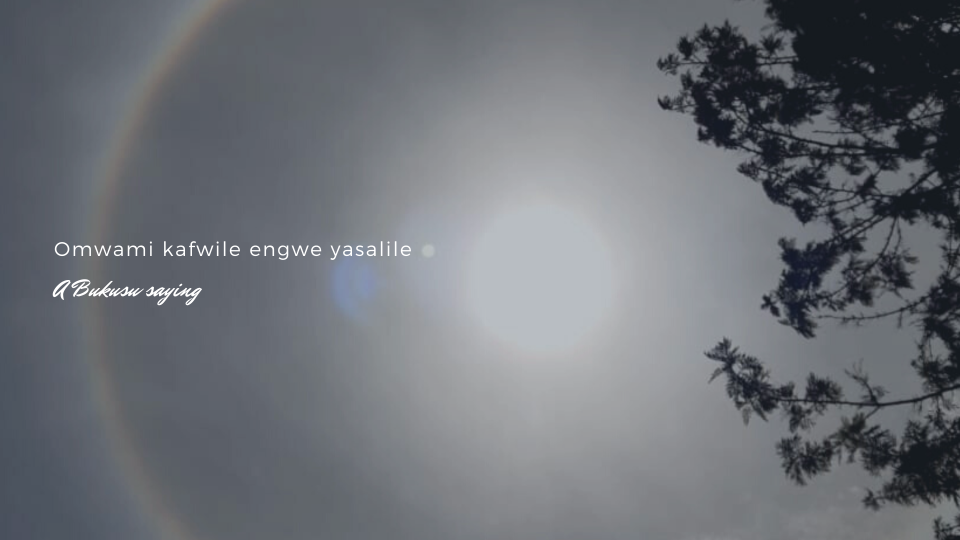 poster with image of sun with ring around it titled omwami kafwile engwe yasalile