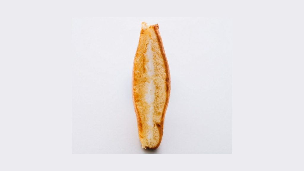 a bread sandwich with cream upon a grey background