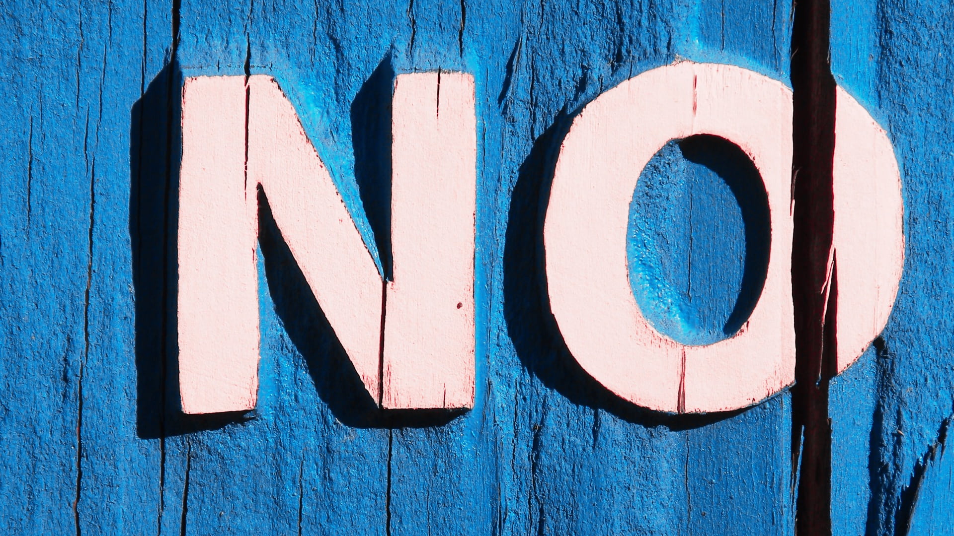 the words no painted in pink block letters upon a blue background